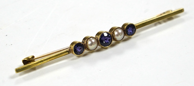 An Edwardian 15ct, three stone sapphire and two stone split pearl set bar brooch, 64mm, gross weight 3.4 grams. Condition - fair to good
